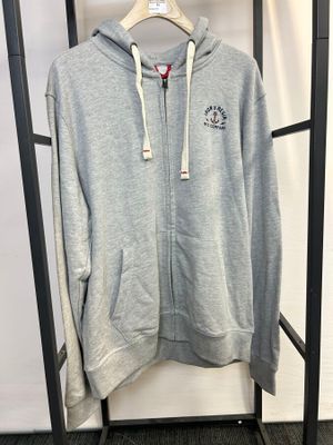 un sweat à capuche gris suspendu à un porte-vêtements dans une pièce