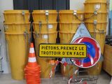 a sign that is on the ground next to some yellow buckets