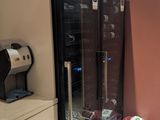 a refrigerator in the corner of a room with a lot of clutter on the floor