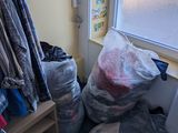 a pile of clothes sitting on the floor next to a window