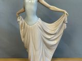 une figurine représentant une femme en robe, posée sur une table