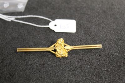 a close up of a gold hair pin with a tag on it