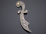 une broche en argent avec une perle au centre