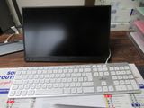un ordinateur portable posé sur un bureau, à côté d'un clavier