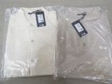 two white shirts wrapped in plastic on a table