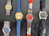 five different watches on display in a glass case