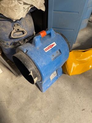 un aspirateur bleu et jaune posé à côté d'une poubelle