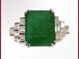 une bague en émeraude et diamants, ornée de diamants taille baguette sur fond blanc