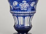 un vase bleu avec des fleurs posé sur une table