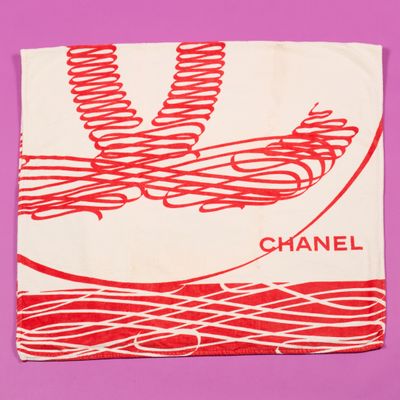 une écharpe rouge et blanche sur laquelle est inscrit le mot « Chanel »