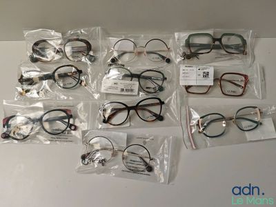 de nombreuses paires de lunettes dans des étuis posés sur la table