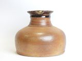 a brown vase sitting on a white surface