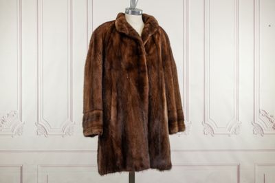 an image of a fur coat on a mannequin stand in front of a wall