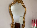 un miroir accroché au mur au-dessus d'une table sur laquelle sont posées des bougies