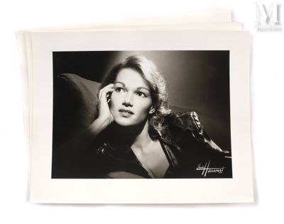 black and white photograph of a woman sitting on a couch talking on a cell phone