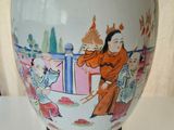 a white vase with a painting on it sitting on a table