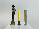 two candles that are sitting on a table next to a statue