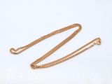 a close up of a gold chain on a white background