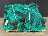 a pile of green fishing nets sitting on top of a wooden pallet