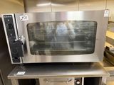 a stainless steel oven sitting on a table in a kitchen