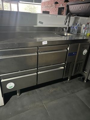 une cuisine équipée d'appareils électroménagers en inox, située au centre de la pièce