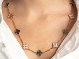 a close up of a woman wearing a white shirt and a gold necklace
