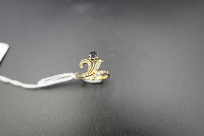 un petit serpent en or suspendu à un cordon blanc