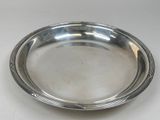 an antique silver plate on a white table with a white background