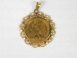un pendentif en forme de pièce d'or sur lequel est représentée une femme