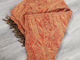 un gros plan sur une écharpe à motifs paisley orange posée sur un parquet