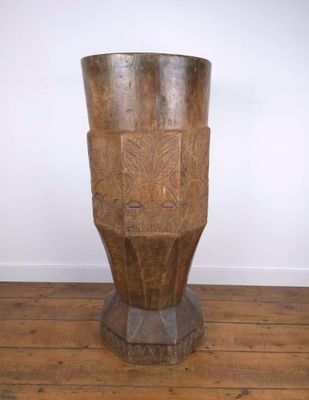 un vase en bois posé sur un parquet