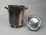 un vase en argent et une assiette en argent posés sur une table