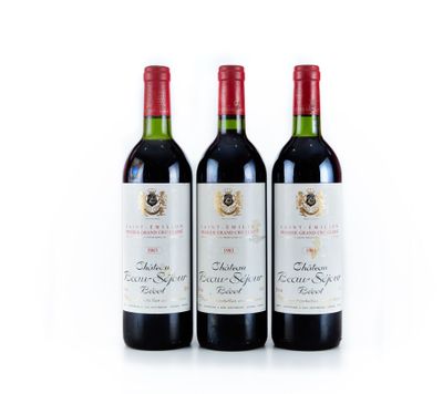 trois bouteilles de vin rouge posées l'une à côté de l'autre sur une surface blanche