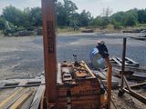 un homme qui se tient à côté d'un tas de bois