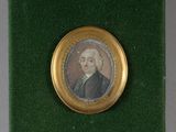 portrait d'un homme en costume-cravate, dans un cadre doré posé sur un fond vert
