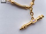 gold plated bracelet with a gold plated tube charm on a gold plated chain