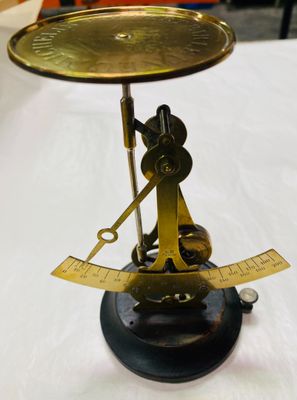 a brass scale with a ruler on it on a table