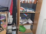 a book shelf with books and a laptop on top of it