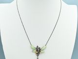 a white mannequin with a green and black necklace on it