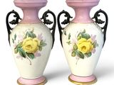 two vases with flowers painted on them on a white surface