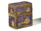 une boîte violette et dorée posée sur une table