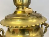 a gold vase with a lid on a table