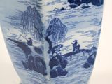 a blue and white vase sitting on a white table