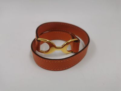 bracelet en cuir orné de lunettes plaquées or sur fond blanc