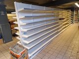 de nombreuses étagères vides dans un magasin, posées à même le sol