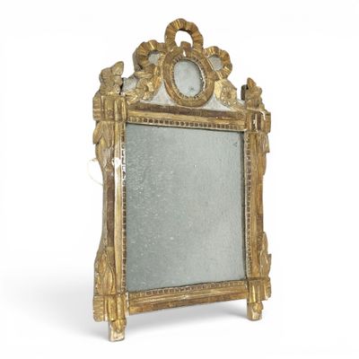 un miroir posé sur un pied, sur une surface blanche