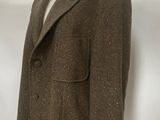 a suit on a mannequin stand in front of a white wall