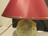 a lamp that is sitting on a table with a red shade on it