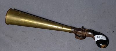 a brass horn shaped like a gun on a table