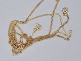 un collier en or auquel est attachée une chaîne